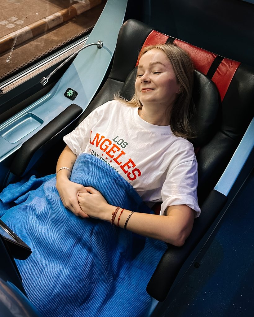 A girl sleeping on a Sombat Super VIP bus