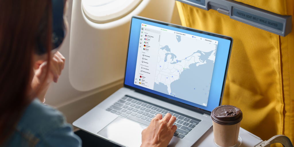 Stock photo of a person on a plane using a laptop. NordVPN app is open